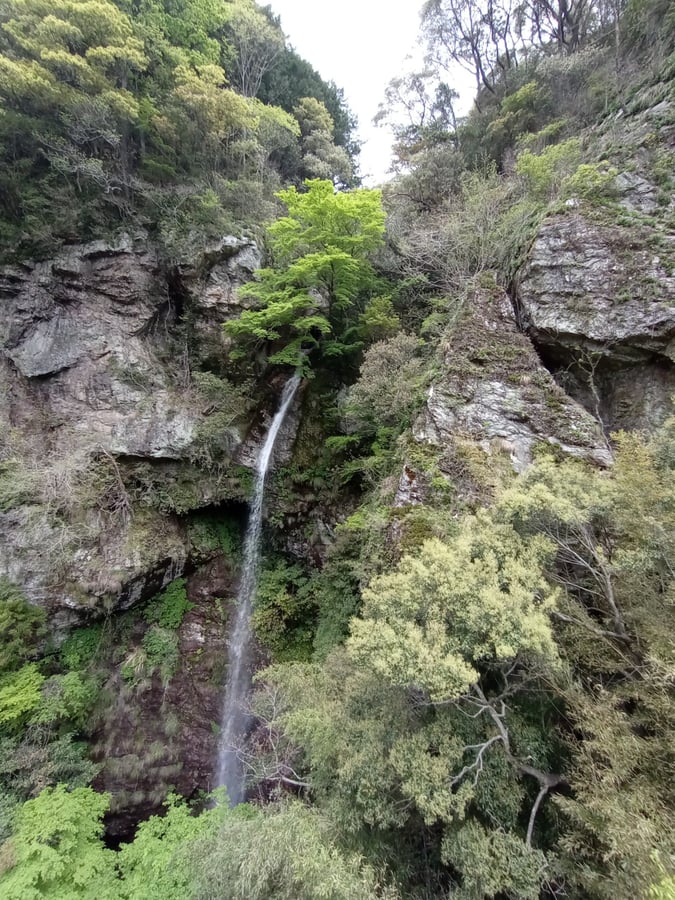 Cascada que cae desde una cueva en la ladera de un acantilado., Japón