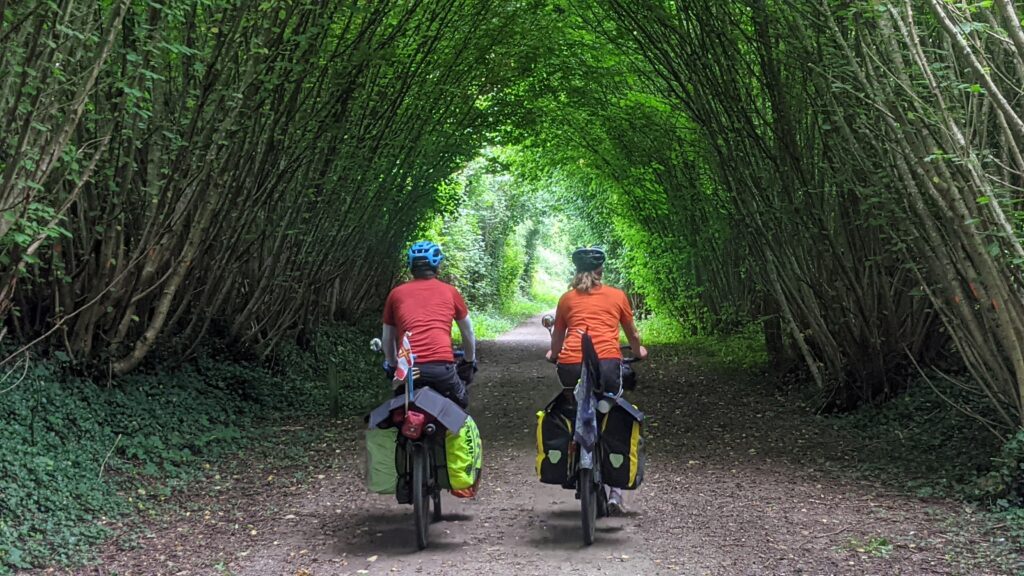 Simon & Lucy cycling along a tree lined track