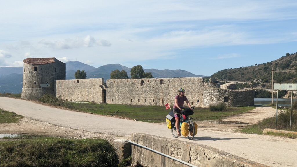 Lucy cycling by fort in Albania